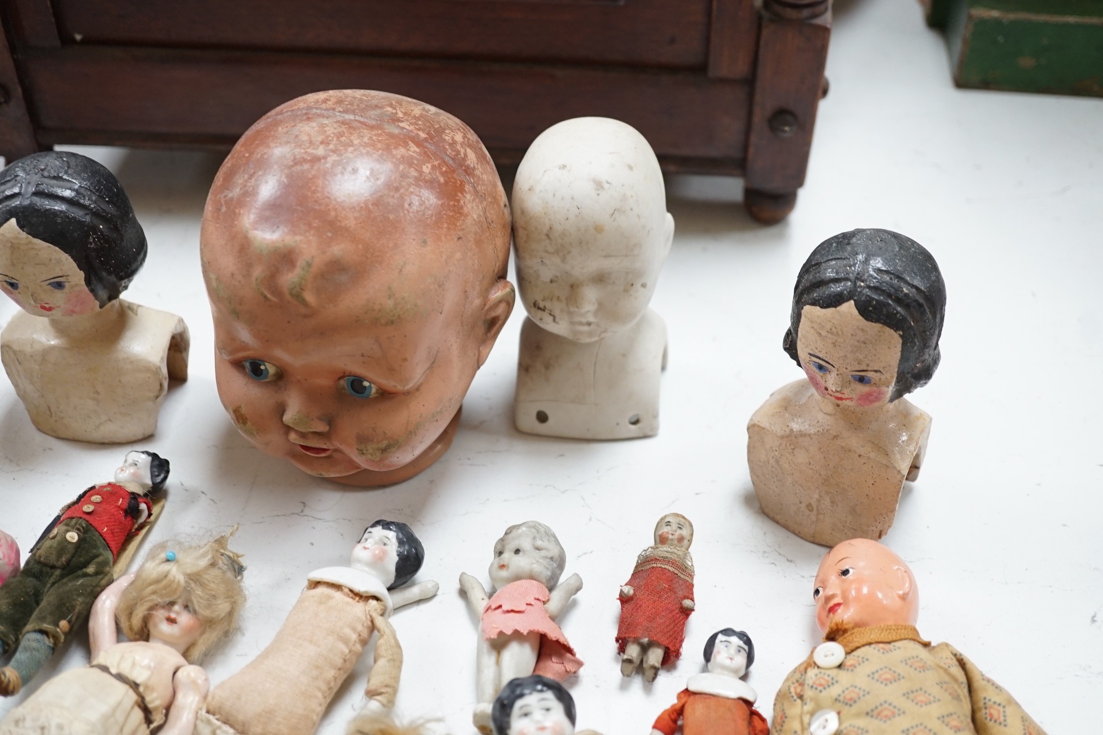 Two Kammer and Reinhardt bisque headed dolls, a wax over composition doll, various other bisque headed dolls and a few single heads and a collection of miniature dolls